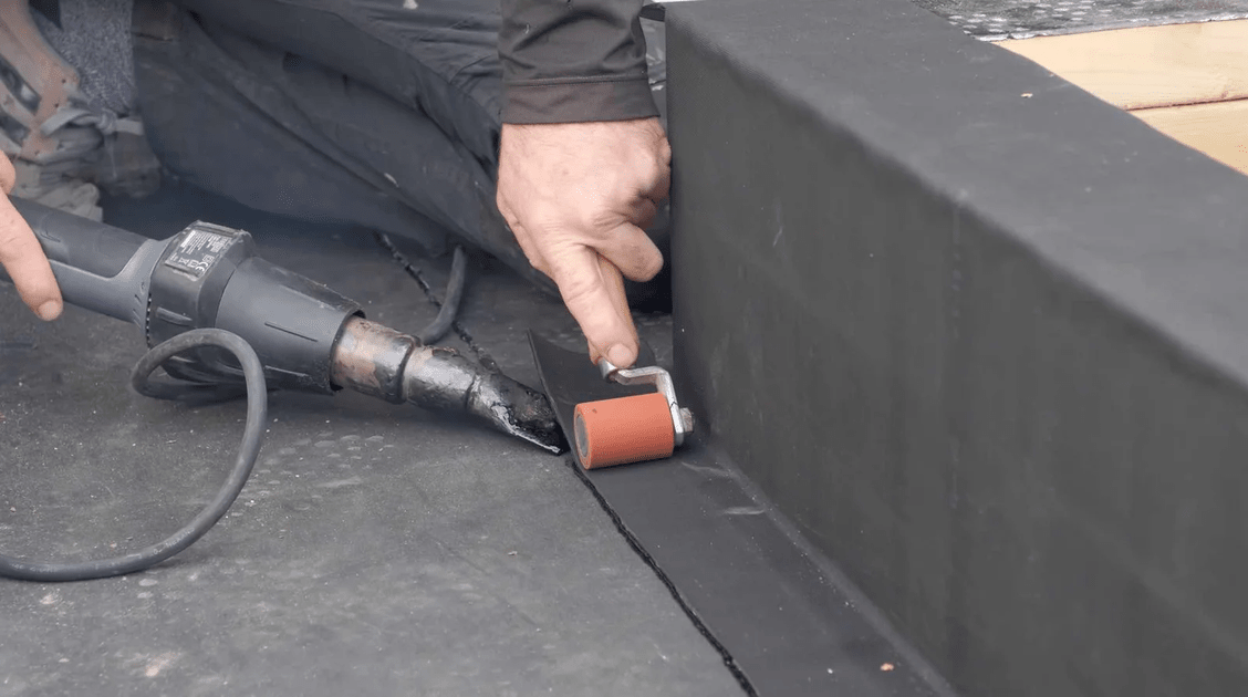 A man working on a concrete asphalt waterproofing