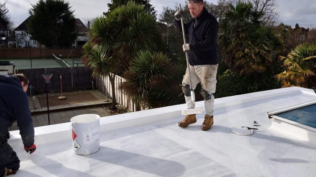 Man applying solar reflective paint to a new Asphalt roof.