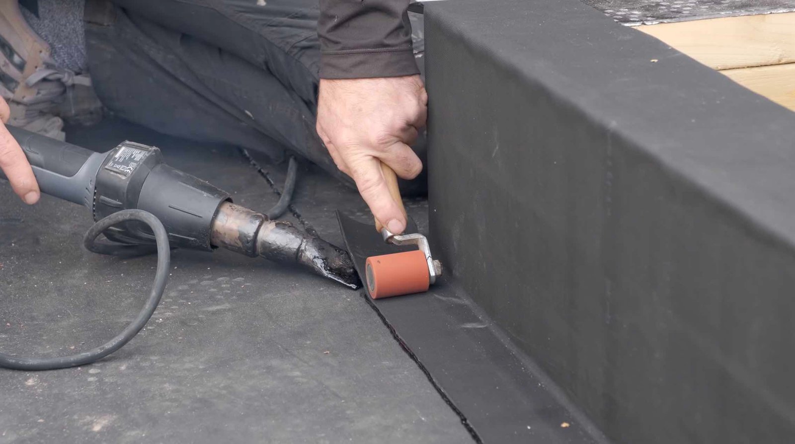 A man expertly using a drill to install EPDM roofing material