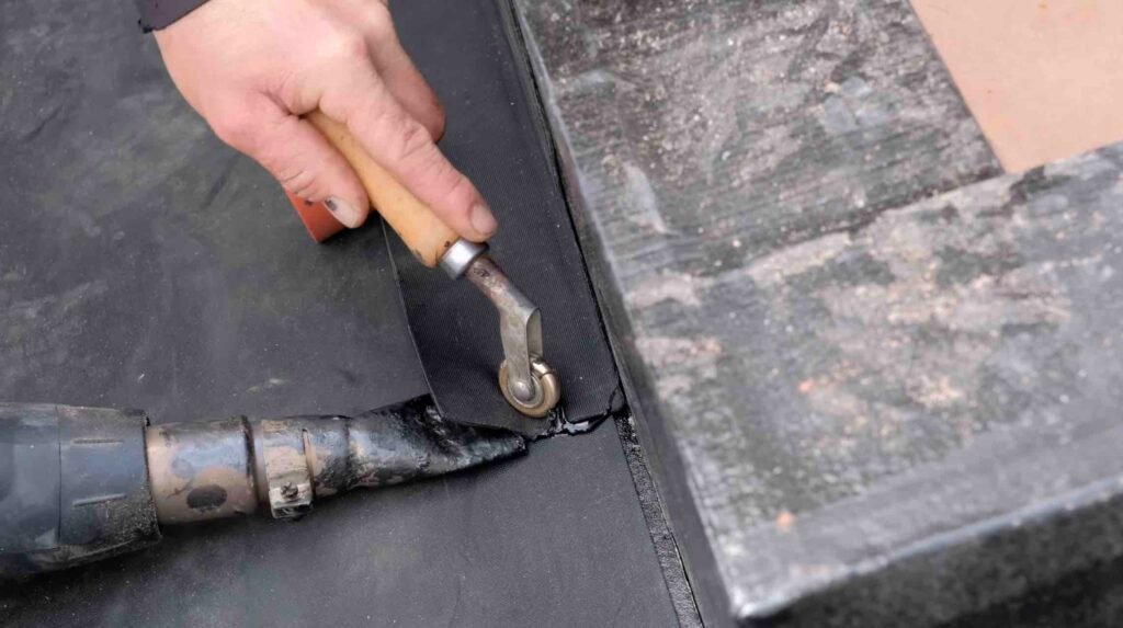 A person using a tool to cut a piece of wood for EPDM roofing installation.