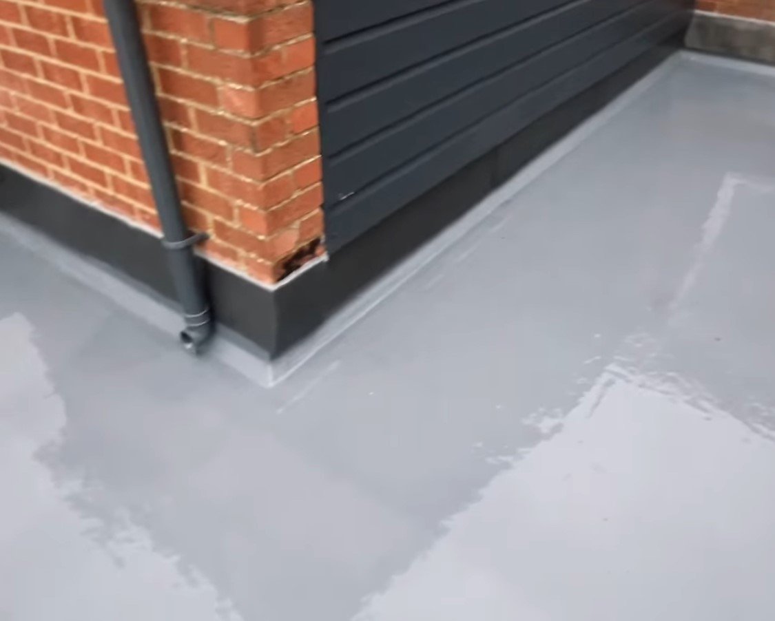 A grey roof above a black garage door, showcasing Liquid Asphalt Waterproofing for enhanced durability and protection.