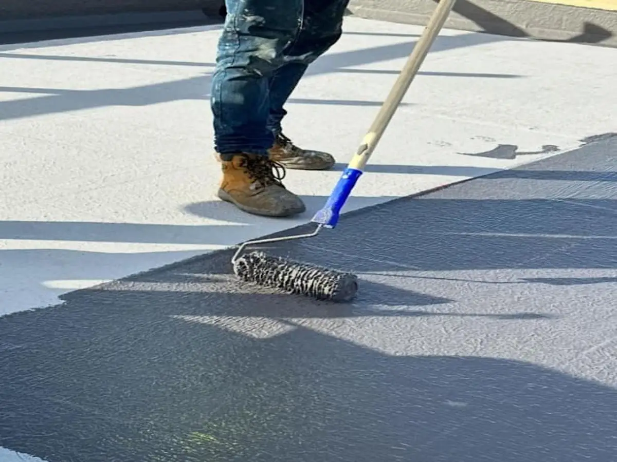 Flat roof waterproofing in London using a roller for smooth application.